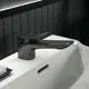 Schwarze Waschtischarmatur von Ideal Standard mit einem flachen Hebel und einer glatten Oberfläche, montiert auf einem weißen Waschbecken.